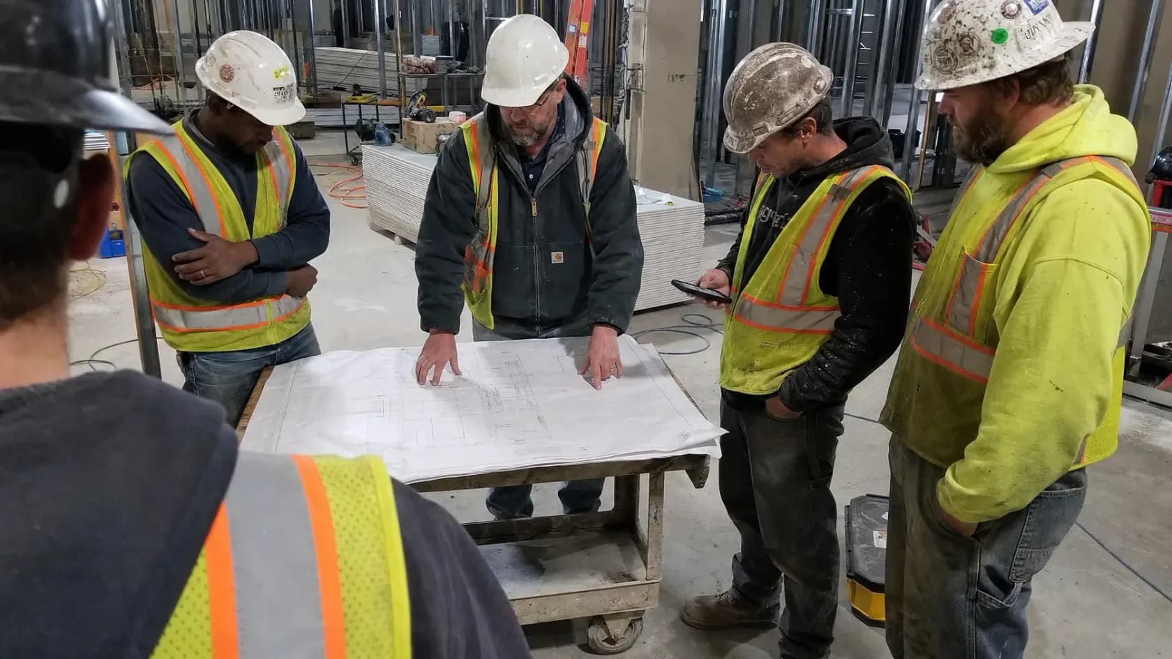 Construction team coordinating from drawings on an active jobsite