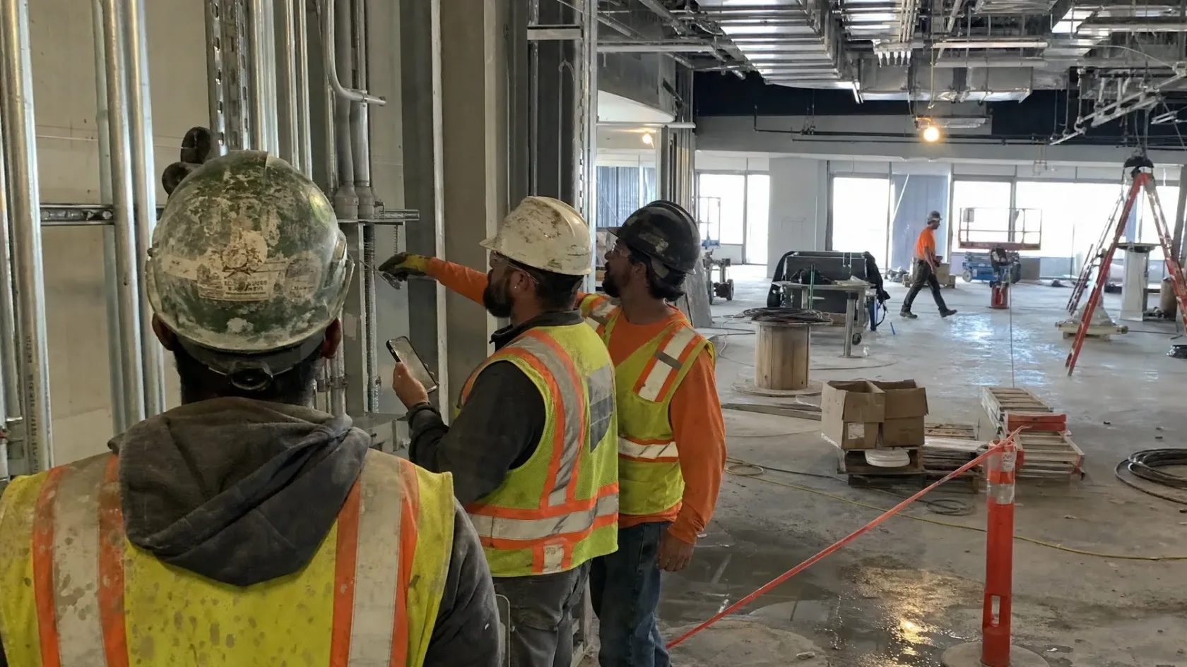 Superintendent documenting installed work with trade partners in the field